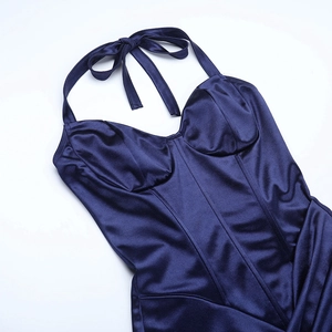 Dettaglio di abito in raso blu navy con allacciatura al collo e cuciture strutturate