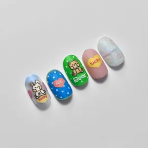 Detail of matte nail stickers featuring cute cartoon bear and rabbit motifs in pastel colors