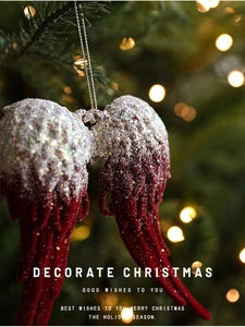 Detail of red flocked Christmas angel wing ornament with silver glitter on tree