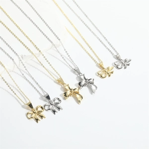 Multiple minimalist bow necklaces shown in gold and silver finishes on a white background