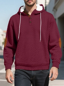 Détail d'un sweat bordeaux avec texture jacquard et empiècements aux coudes