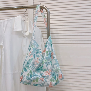Bolso tote de algodón con estampado floral colgado en un perchero de metal