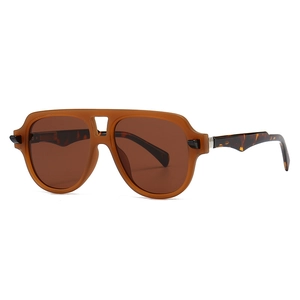 Vintage pilot sunglasses with amber frames and tortoiseshell temples on white background