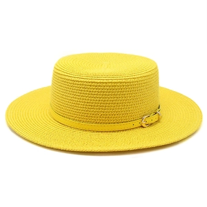 Détail d'un chapeau canotier jaune vif avec texture tressée et fine ceinture en cuir