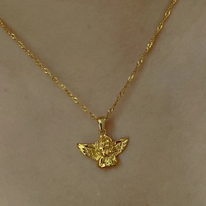 Gros plan du collier avec pendentif ange en acier inoxydable plaqué or 18 carats