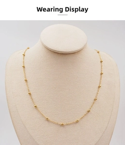 Detail of a thin gold beaded titanium steel chain displayed on a neck bust