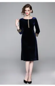 Dettaglio di ricami vintage e perline sui polsini dell'abito in velluto blu scuro