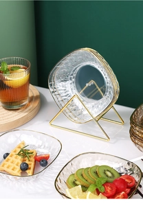 Détail de bols à collation en verre ambré et transparent avec bordure dorée sur support