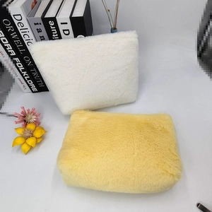 Detail of plush macaron candy color makeup bags in creamy white and bright yellow