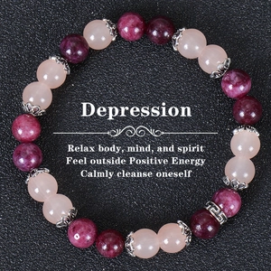 Detail of pink and purple beaded stone bracelet with vintage silver floral spacers on leather