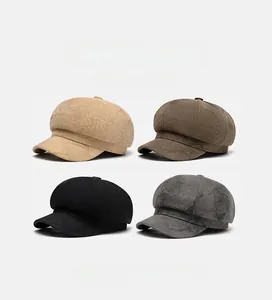 Detalle de cuatro gorras de vendedor de periódicos en ante beige, marrón, negro y gris