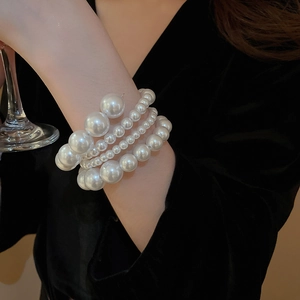 Detail of layered pearl bracelet with gradient beads and creamy finish on velvet