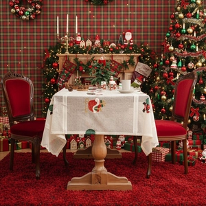 Embroidered Christmas tablecloth with reindeer and socks in festive dining room