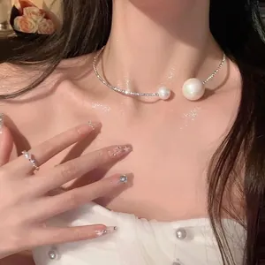 Detail of luxury irregular pearl choker and ring set with sparkling finish on model