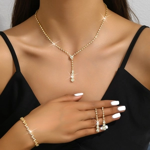 Detail of elegant gold jewelry set with sparkling crystals on a female model