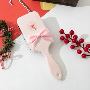 Pink deer cartoon hairbrush with ribbon bow on a festive Christmas background