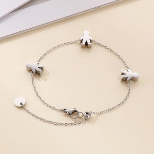 Detail of silver stainless steel bracelet featuring three cartoon character charms and chain