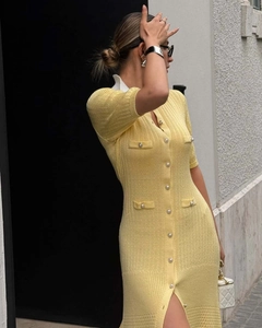 Detail of yellow knit dress featuring decorative flap pockets and white contrast collar