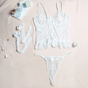 Three-piece white lace lingerie set with chemise, thong and stockings on beige background