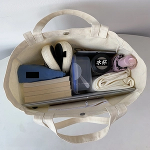Top view of large canvas tote bag showing spacious interior with laptop and essentials