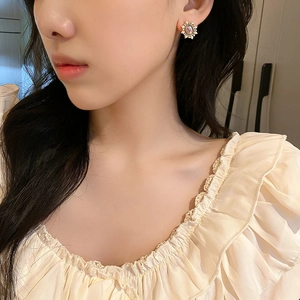 Close-up of vintage oval faux pearl earrings with golden base on model's ear