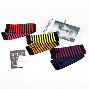 Detail of six colorful striped knitted fingerless arm sleeves with thumb hole design