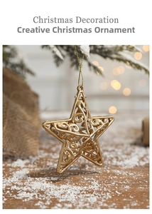 Detailed view of hollow gold star ornament hanging on snowy Christmas tree branch