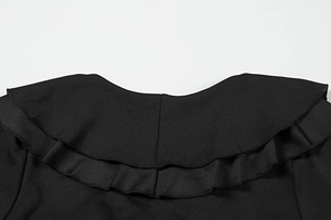 Gros plan du décolleté à double volants sur une robe noire élégante à col en V