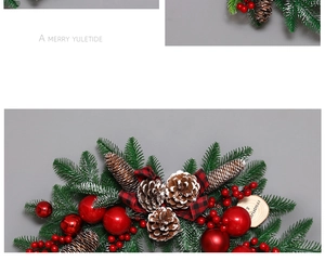 Close-up of Christmas rattan wreath with red berries, pine cones and Merry Christmas wood signs