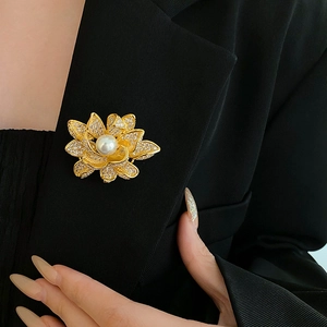 Detail of a gold flower brooch with white pearl and zircons on a black suit lapel