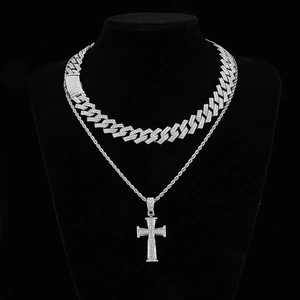 Detail of silver Cuban chain and iced out cross pendant with sparkling rhinestones