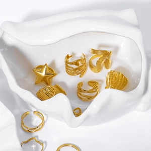 Minimalist 18k gold plated stainless steel star and shell rings in ceramic dish