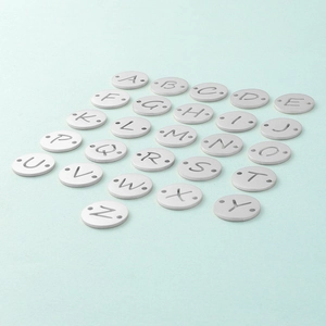 Vue détaillée de 26 pendentifs lettres en acier argenté avec double trou pour bijoux DIY