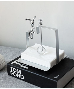 Detailed close-up of a silver bunny napkin holder with a crystal weight on a square base