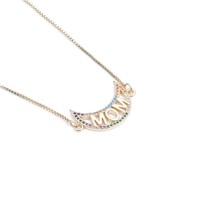 Close-up of gold crescent moon pendant with colorful MOM lettering and zircons