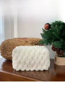 Close-up of white plush popcorn texture makeup bag on a wooden table for travel storage