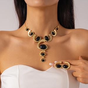 Détail de parure collier et bague dorés avec grandes pierres ovales noires en résine