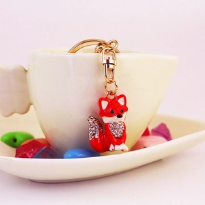 Red fox keychain with enamel finish and crystals in a decorative heart-shaped white cup