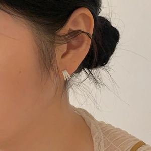 Close-up of minimalist 925 silver stud earrings with sparkling cubic zirconia on model