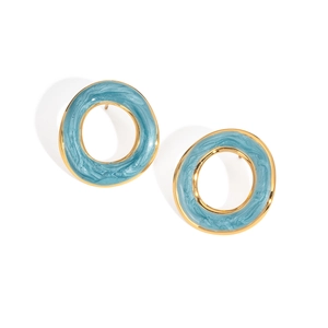 Détail de boucles d'oreilles rondes en métal doré avec finition émail bleu sur fond blanc