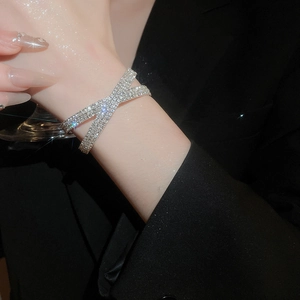 Détail du bracelet croisé double couche en argent brillant avec sertissage pavé de diamants
