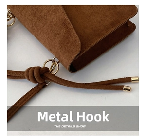 Detailed close-up of brown suede bag featuring gold metal hook and decorative drawstring