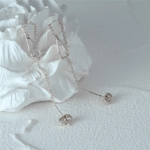 Macro detail of S925 sterling silver long chain earrings with geometric drop pendant