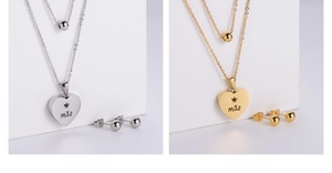 Detailed macro view of heart pendant with crown engraving and round stud earrings set