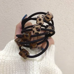 Elastic leopard print hair ties set with acrylic square beads shown on a model hand