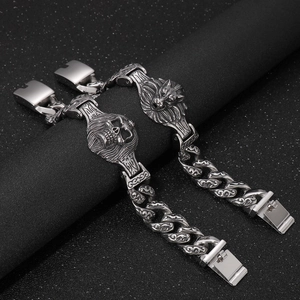 Macro detail of gothic 304 stainless steel wolf and skull head charms on Cuban chain