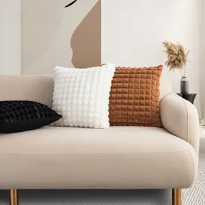 Detail showing 3D textured plaid plush pillow covers in black white and caramel brown