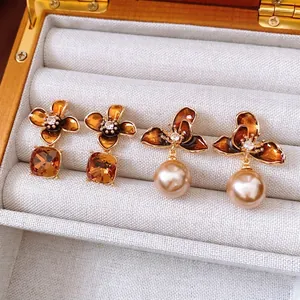 Vintage gold-plated floral earrings with amber stones and pearls in a jewelry box