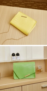 Detail of yellow and green crocodile texture chain bags with gold metal bar accents