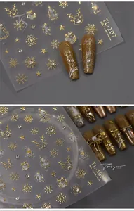 Detailed view of Christmas elk and golden snowflake nail decals on dark matte finish nails